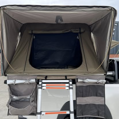 Inside a fitted rooftop tent with ladder and gear pockets