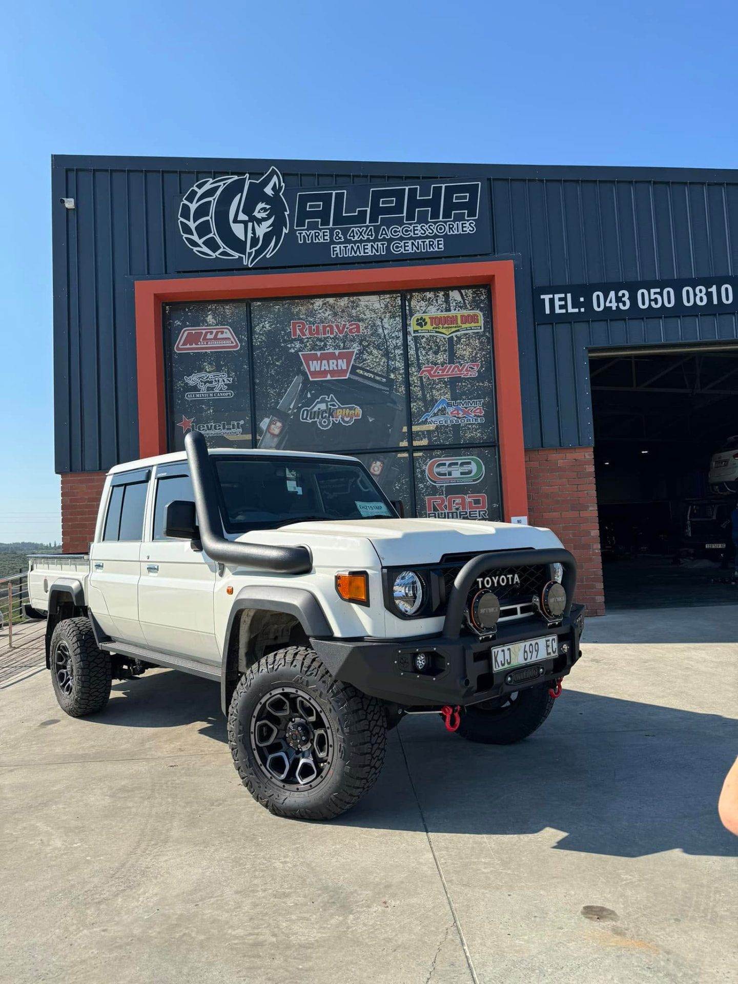 Toyota Land Cruiser 79 double-cab fitted with a RAD bull bar, winch, suspension lift, snorkel and off-road tyres outside the Alpha Tyre & 4x4 fitment centre in East London