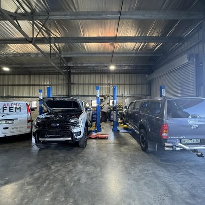 Inside the Alpha workshop bays with a Ranger and Hilux on the lifts