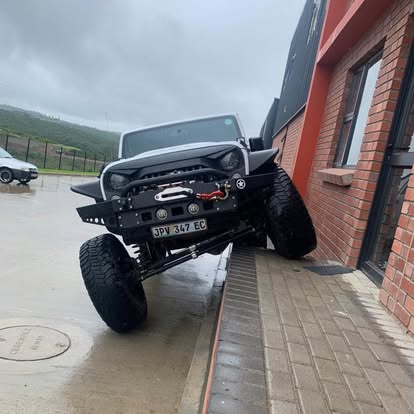 Lifted Jeep Wrangler on 35s with winch bumper outside the workshop