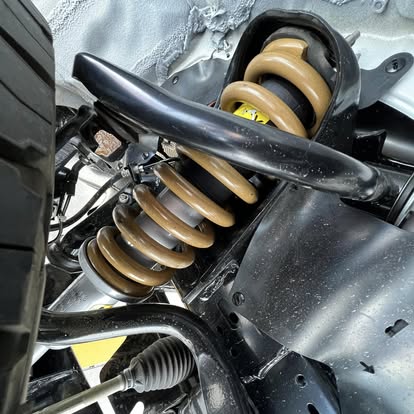 Front coil spring and suspension components fitted underneath a bakkie