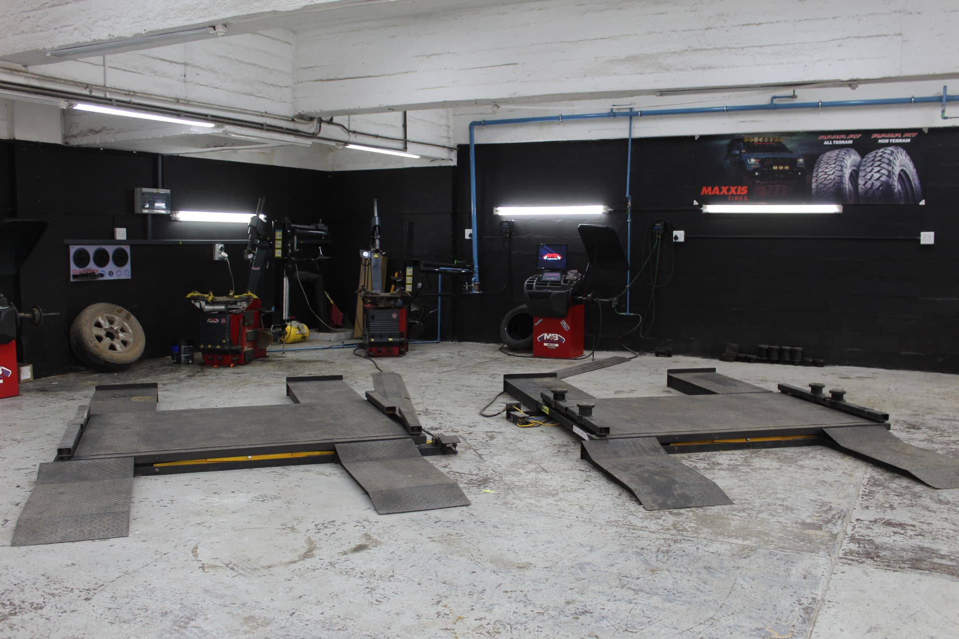 The Alpha tyre bay with scissor lifts, red tyre changers and the Maxxis RAZR wall