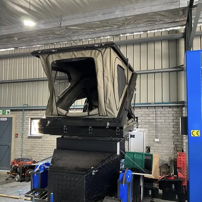Hard-shell rooftop tent opened on a custom off-road trailer